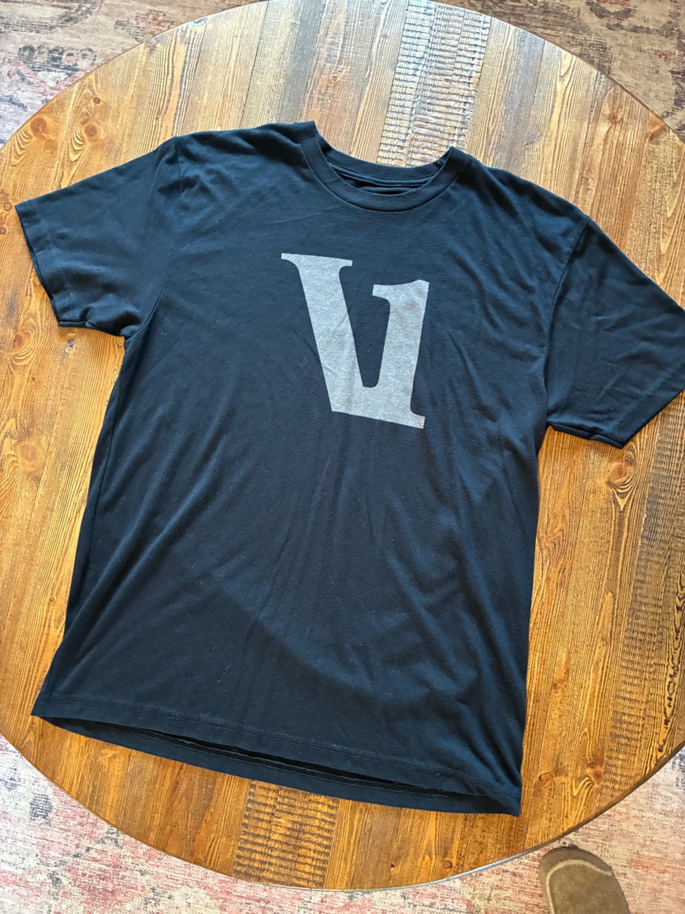Vuori Black Short Sleeve Tee with Large Gray 'V' Logo Center